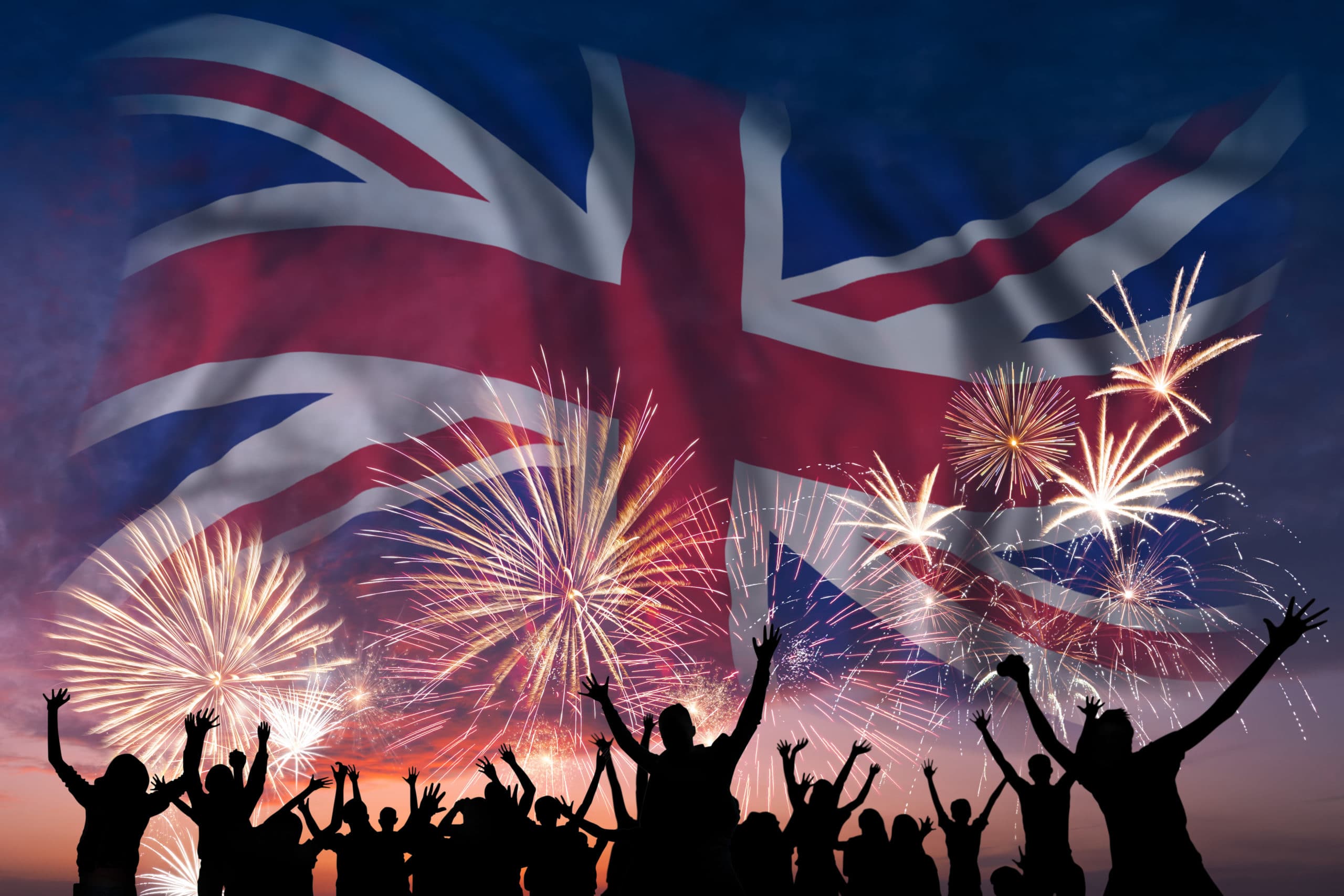 What time can I set fireworks off in the UK? Happy people are looking holiday fireworks with flag of United Kingdom in sky, independence day